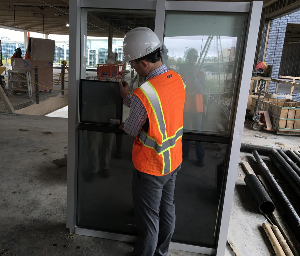 Brandon Rich comparing windows at the 1201 Cass construction site