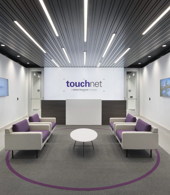 Interior shot of one of TouchNet Information Systems' seating areas showcasing digital signage and lighting